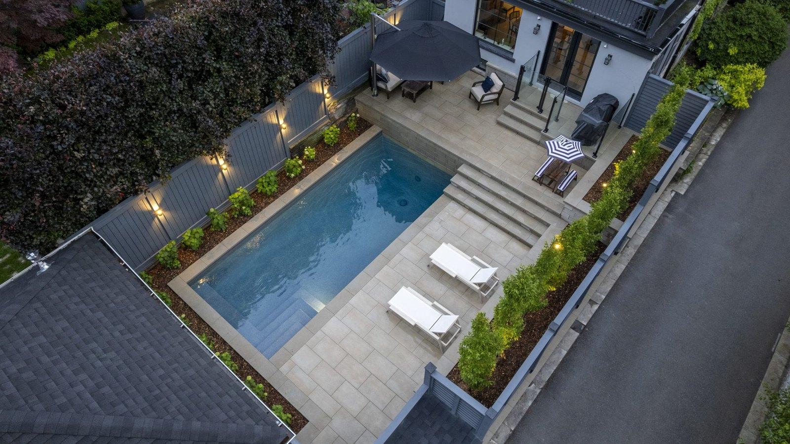 A Betz pool and sun deck lit at dusk, seen from above